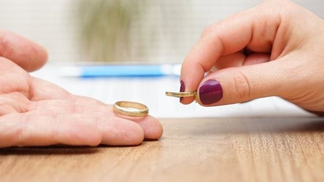Two hands holding wedding rings