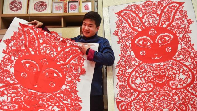 Artysta ludowy prezentuje wyciętą z papieru grafikę przedstawiającą 106 królików na powitanie zbliżającego się Święta Wiosny w Chinach, 15 stycznia 2023 r. W Luoyang, prowincja Henan, Chiny.