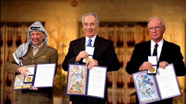 Yasser Arafat (left) poses with Israeli Prime Minister Yitzak Rabin and Israeli Foreign Minister Shimon Peres during the Nobel Peace Prize ceremony in 1994