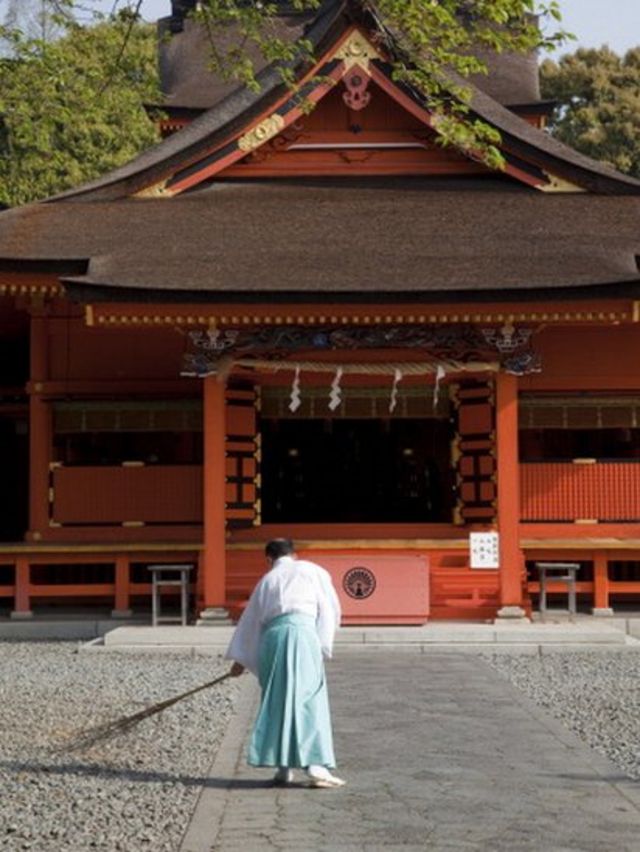 Man cleaning the gardens of a temple