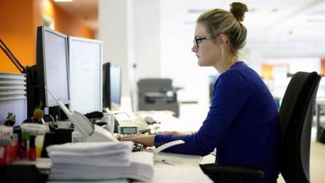 Mulher mexendo em computador no escritório
