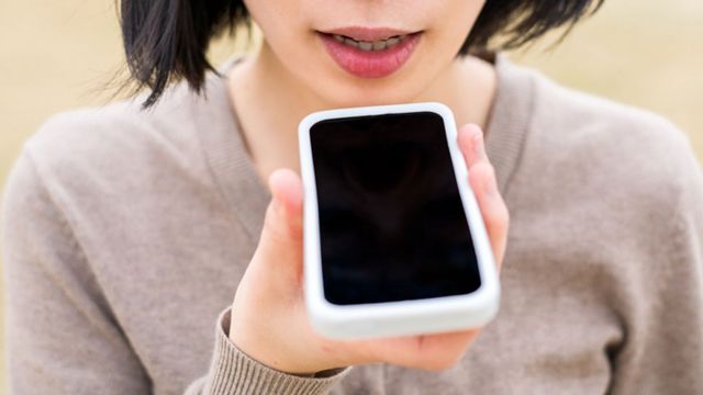 Joven hablando a un celular en su mano