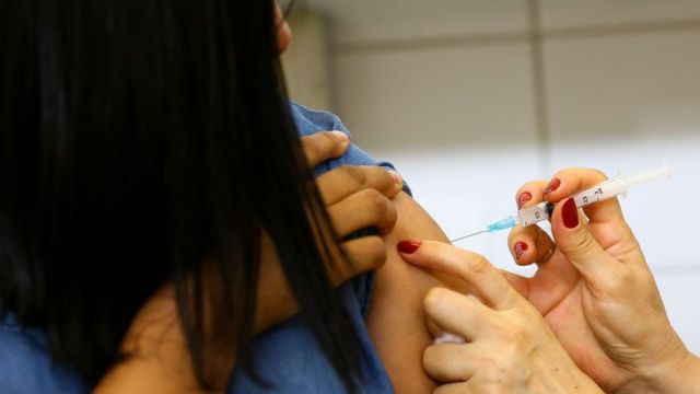Mulher recebendo vacina contra sarampo