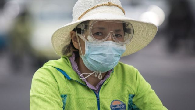 Женщина в маске на велосипеде в Ухане