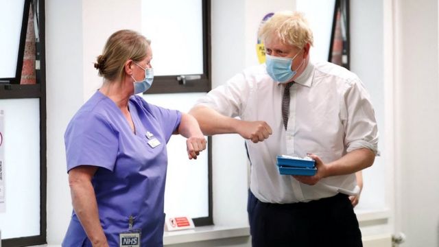 El primer ministro británico, Boris Johnson, saluda a un miembro del personal de vacunación durante una visita a un centro de vacunación contra la enfermedad del coronavirus (COVID-19) en Northampton, Reino Unido, el 6 de enero de 2022.