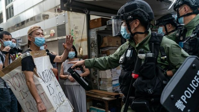 A man wearing a Voting Is A Right costome stand off with riot police during an anti-government protest on September 6, 2020 in Hong Kong