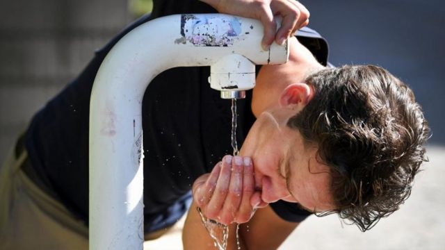 Un homme boit de l'eau d'un débit de boisson public pendant une vague de chaleur à Nimègue, aux Pays-Bas, le 18 juillet 2022.