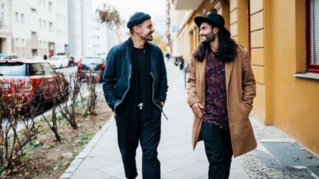 Dois homens andando na rua e conversando