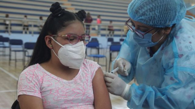 Niña ecuatoriana recibiendo su vacuna de covid-19