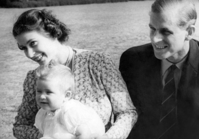 La princesa Isabel de Inglaterra y su esposo, el príncipe Felipe, duque de Edimburgo, con su bebé, el príncipe Carlos, en julio de 1949 en Windlesham Moor, Surrey.