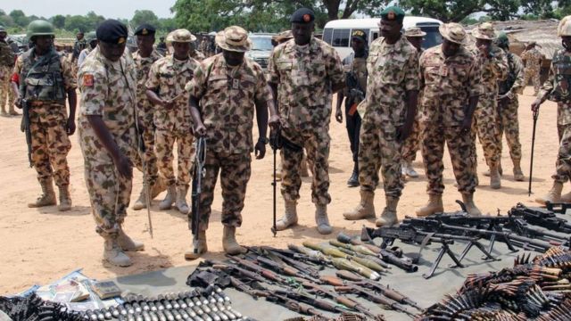 Des commandants militaires inspectent des armes et des munitions récupérées auprès des djihadistes de Boko Haram, exposées au quartier général du 120e bataillon à Goniri, dans l'État de Yobe, dans le nord-est agité du Nigeria, le 3 juillet 2019.