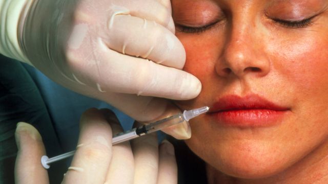 Woman having botox injection in lips