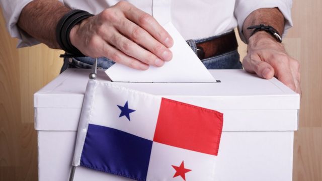Urna con bandera de Panamá y hombre votando