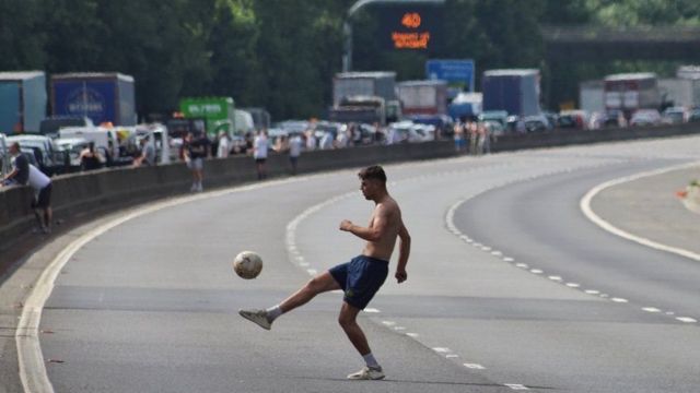 الرجل يلعب كرة القدم في الاتجاه الخالي من الطريق