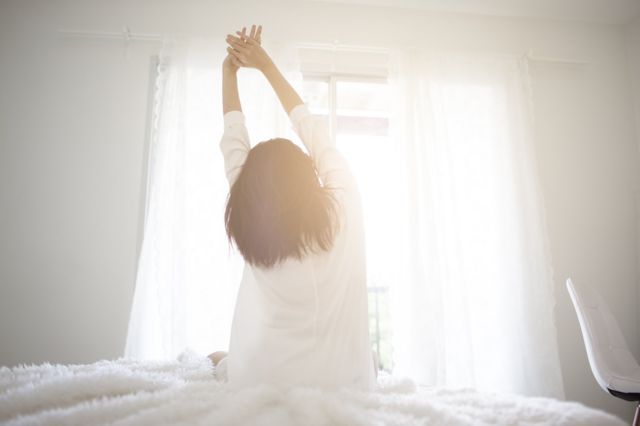 Una mujer se reincorpora de la cama después de tener un buen sueño