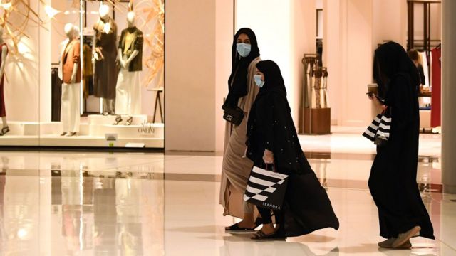 Women wearing face masks walk in the Mall of Dubai on 28 April 2020