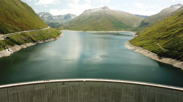 A reservoir surrounded by mountains on three sides and a dam at the bottom
