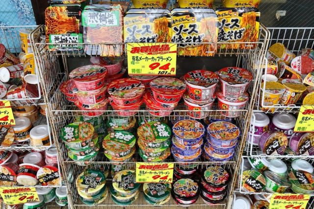 Shelves stacked full of pots of instant ramen, at a convenience shop in Tokyo, Japan.