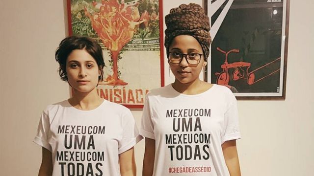 Luísa Arraes e Gabriela Bispo posam para foto com a camiseta da campanha contra assédio