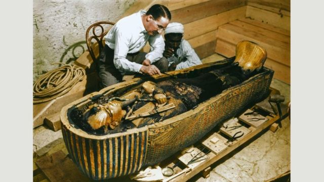 1925年10月29日到30日：卡特和一名埃及工人在检查第三层（最里面的）纯金棺材(photo:BBC)