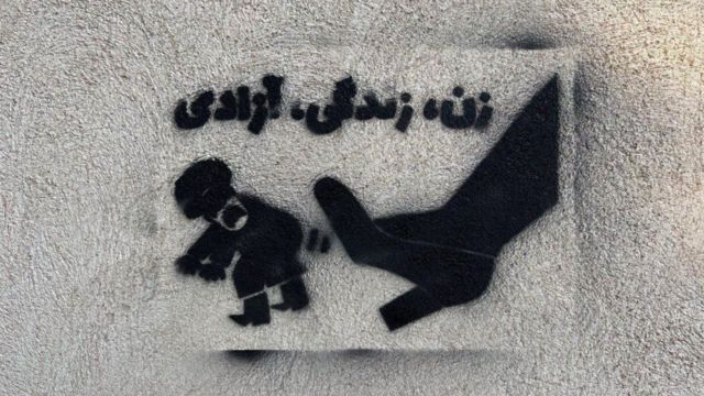 ภาพวาดบนกำแพงที่อีกเครื่องมือหนึ่งของผู้ประท้วงในอิหร่าน โดยในภาพนี้คือ ภาพรองเท้าของผู้หญิงเตะตำรวจ และมีคำว่า ผู้หญิง, ชีวิต และเสรีภาพ อยู่ด้านบน