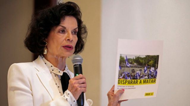 Mujer señalando informe de Amnistía Internacional