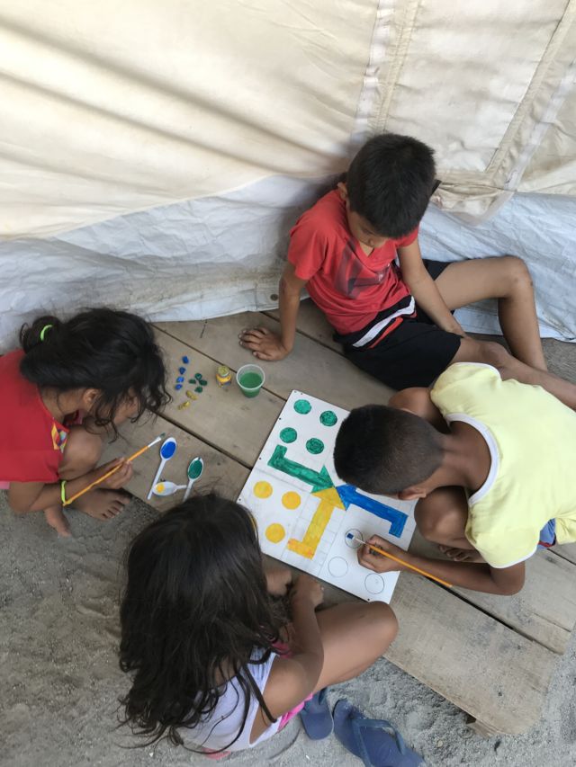 Niños haciendo su propio tablero de juego en Boa Vista.