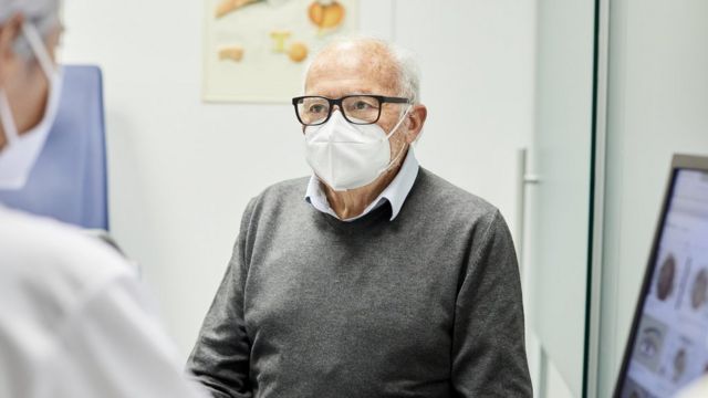 An old man wearing a face mask