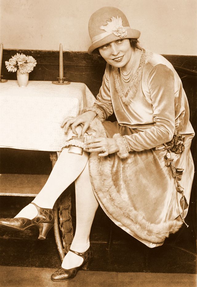 chica de Washington DC que en 1926 sonríe mostrando dónde escondía su whisky.