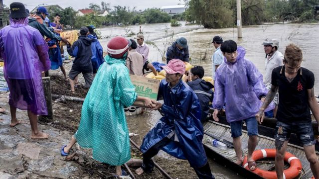 Local residents and volunteers deliver aid packages to residents affected by heavy flood in Quang An Commune, Thua Thien Hue, Vietnam, 20 October 2020