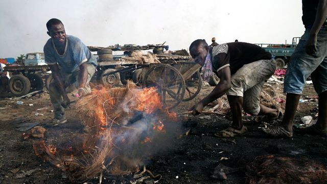 Un hombre joven quema basura electrónica en Agbogbloshie en Ghana