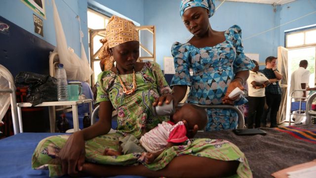 Umukozi w'ikigo gitanga imfungurwa riko aragaburira umwana agwaye ingwara y'imirire mi mu bitaro vya Molai General Maiduguri muri Nigeria mu kwezi kwa 11 itariki 30, 2016.