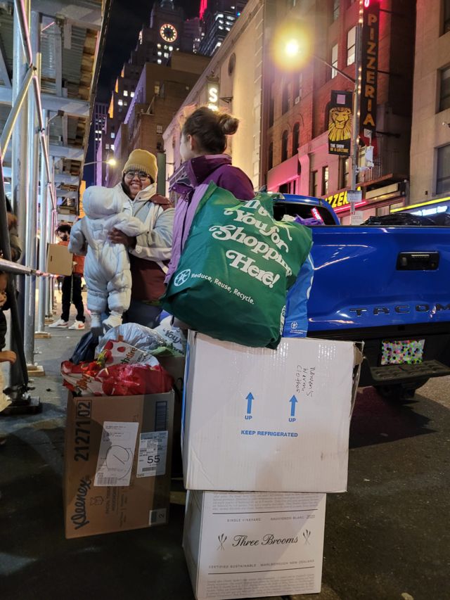 Membros do restaurante La Morada oferecem doações para imigrantes em uma noite fria de novembro em Manhattan