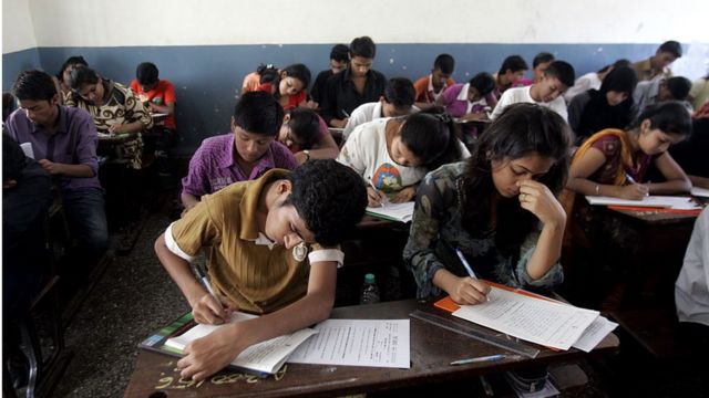 Varios escolares resuelven un examen en un salón humilde