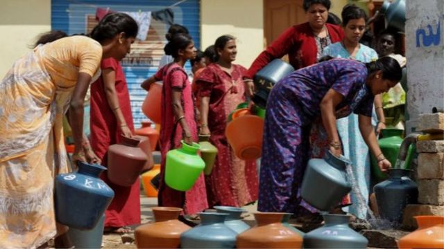هنديات يملأن أوعية بالماء من صنبور عام