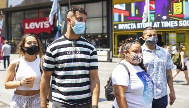 Những người đeo khẩu trang đi qua Quảng trường Thời đại ở New York, Mỹ, ngày 27 tháng 7 năm 2021