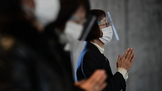 A worshipper wearing a plastic visor and face mask prays during Christmas Day Mass at St. Mary's Cathedral on December 25, 2020 in Tokyo, Japan.