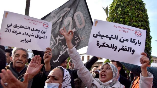 مغاربة يرفعون لافتات أثناء تجمعهم أمام البرلمان في العاصمة الرباط للاحتجاج على ارتفاع الأسعار، 20 فبراير 2022