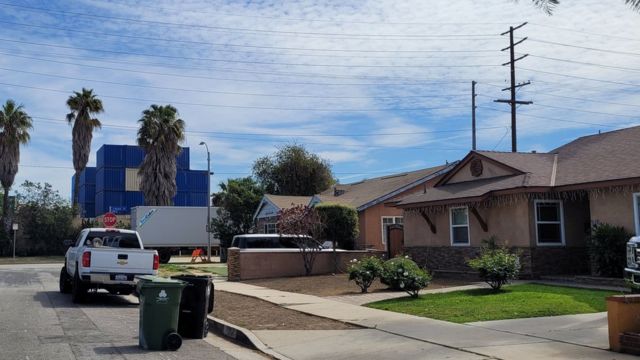 Containers stacked in front of houses.