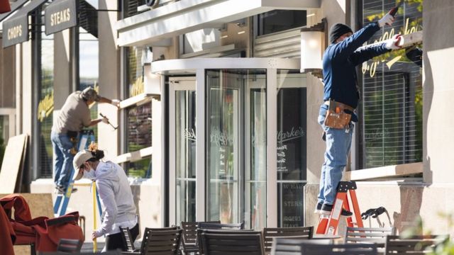 Workers board up windows at a Washington restaurant ahead of election day
