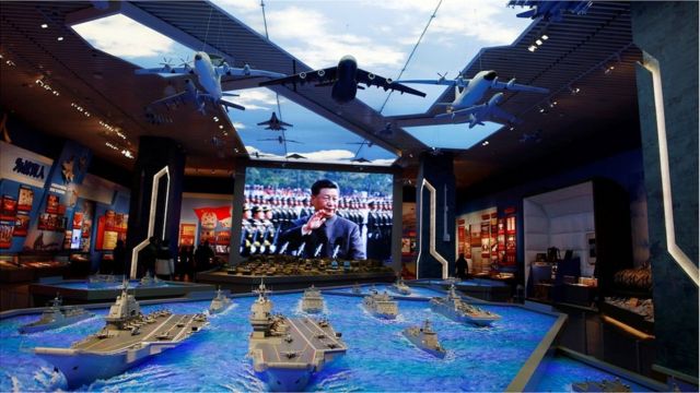 Models of military equipment and a giant screen displaying Chinese President Xi Jinping are seen at an exhibition at the Military Museum of the Chinese People