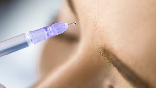Injection of hyaluronic acid near a woman's forehead