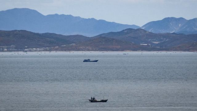 Unidentified fishing boats before the North Korean coastline from a viewpoint on the South Korea-controlled island of Yeonpyeong near the disputed waters of the Yellow Sea at dawn.