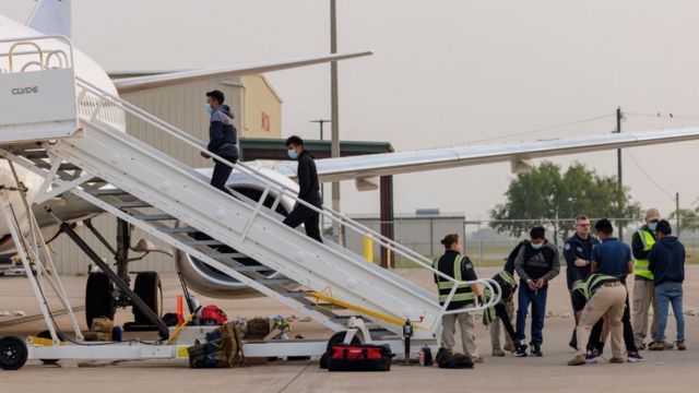 Migrantes abordan un avión de devolución a sus países