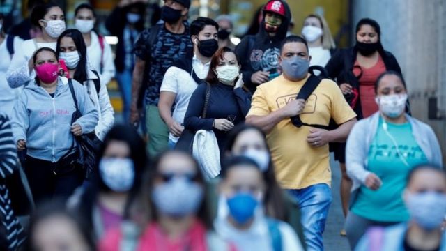 Pessoas de máscara na rua em São Paulo