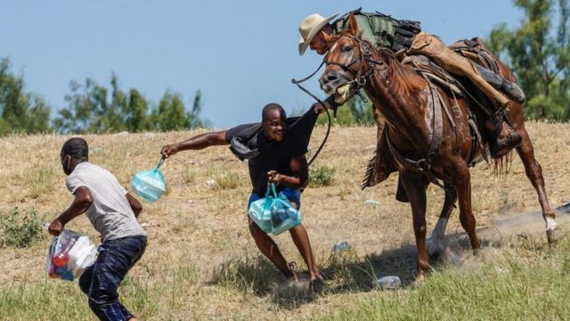Un agent de patrouille frontalière du Texas tire un migrant par sa chemise depuis son cheval