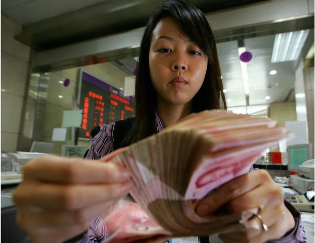 北京一位银行职员在清点钞票