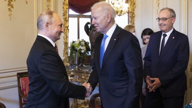 Putin y Biden estrechando manos.