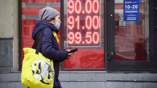 Mujer caminando fuera de una casa de cambio