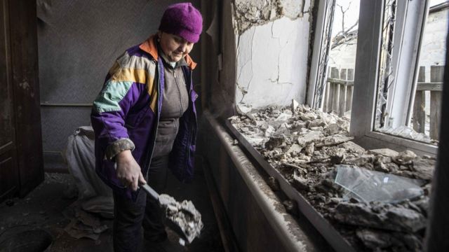 Una mujer recoge los escombros tras una explosión en Donetsk